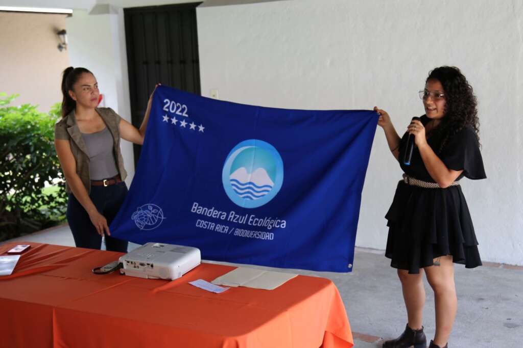 Jeldryn Vargas (left), receives the Biodiversity Blue Flag from Silvia Rodriguez (right) CONAGEBIO representative.